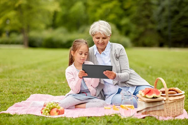 Babcia i wnuczka z tabletu w parku — Zdjęcie stockowe