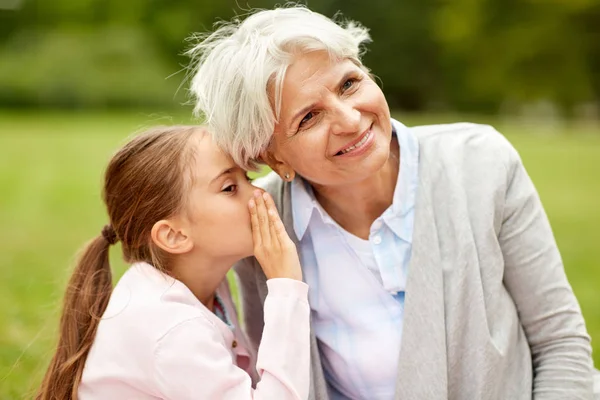 Granddaughter sharing secrets with grandmother — Stock Photo, Image