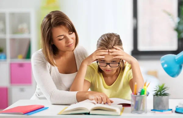 Mère aidant fille avec des devoirs difficiles — Photo