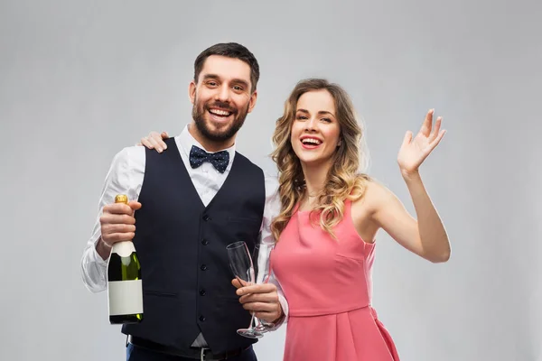 Casal feliz com garrafa de champanhe e copos — Fotografia de Stock