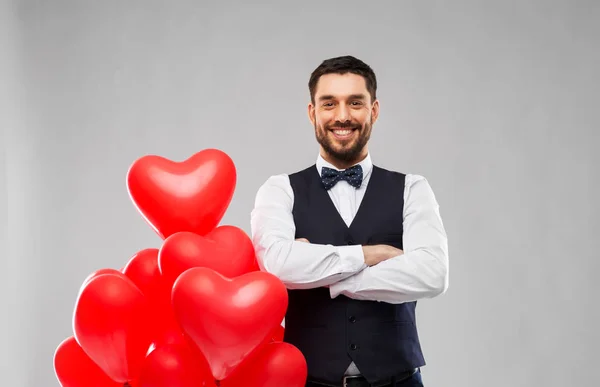 Hombre feliz con globos en forma de corazón rojo —  Fotos de Stock