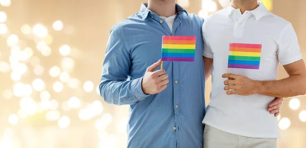 Close up de masculino gay casal segurando arco-íris bandeiras — Fotografia de Stock