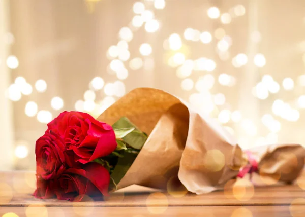 Крупним планом червоні троянди букет, загорнуті в папір — стокове фото