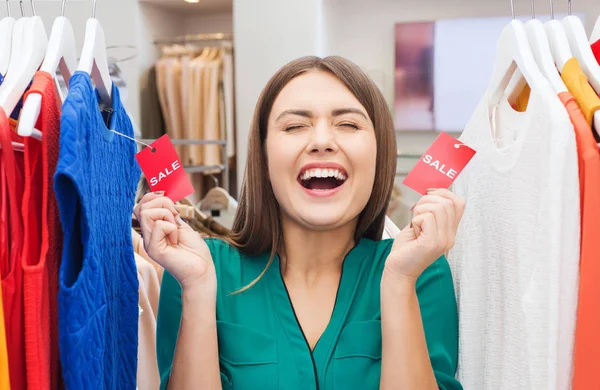 Glückliche Frau mit Verkaufsetiketten im Bekleidungsgeschäft — Stockfoto