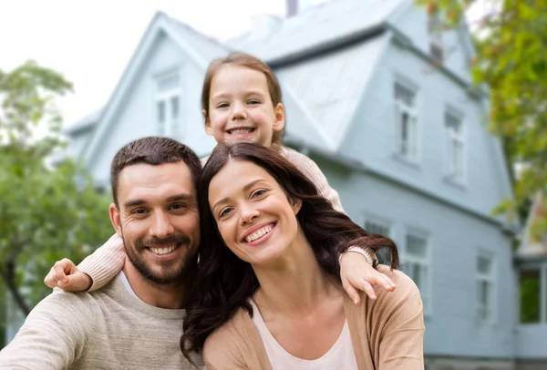 Lycklig familj över huset bakgrund — Stockfoto
