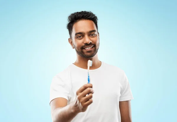 Uomo indiano con spazzolino da denti su sfondo blu — Foto Stock