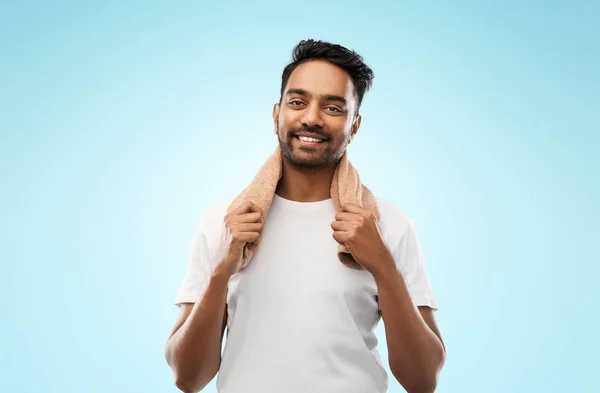 Uomo indiano sorridente con asciugamano su sfondo grigio — Foto Stock