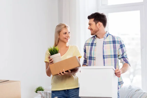 Feliz pareja con cajas mudándose a un nuevo hogar — Foto de Stock