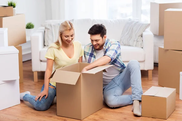 Feliz pareja desembalaje cajas en nuevo hogar —  Fotos de Stock