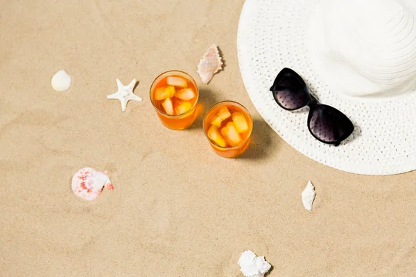 Drinkar, sol hatt och solglasögon på stranden sand — Stockfoto