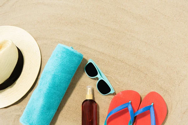 Sombrero de paja, chanclas y gafas de sol en arena de playa —  Fotos de Stock