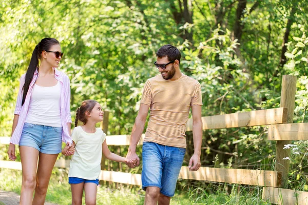 Счастливая семья, гуляющая в летнем парке — стоковое фото