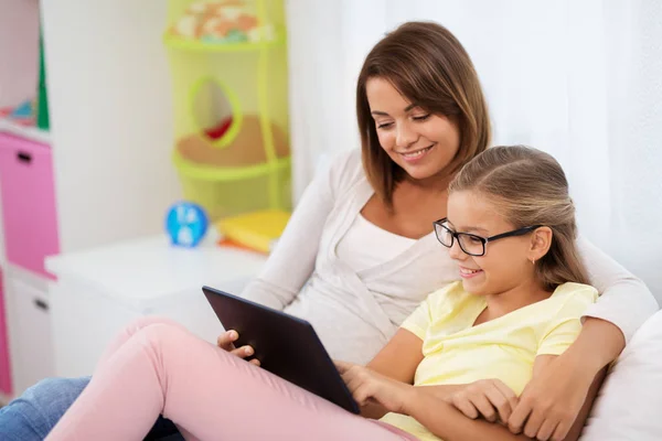 Mãe feliz e filha com tablet pc em casa — Fotografia de Stock