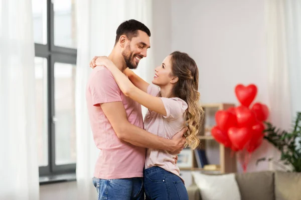 Feliz casal abraçando em casa no dia dos namorados — Fotografia de Stock