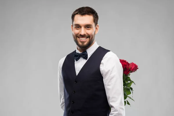 Glücklicher Mann mit roten Rosen auf dem Rücken — Stockfoto