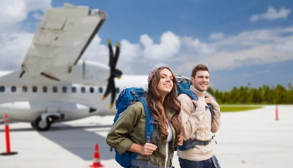 Pareja de turistas con mochilas en avión — Foto de Stock