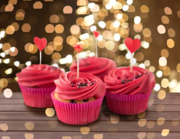 Close up of cupcakes with heart cocktail sticks — Stock Photo, Image