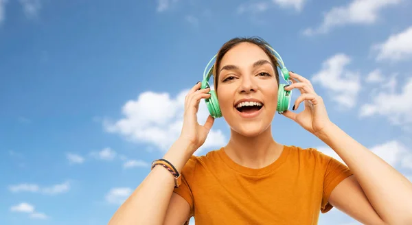 Teenage girl in earphones over sky — Stock Photo, Image