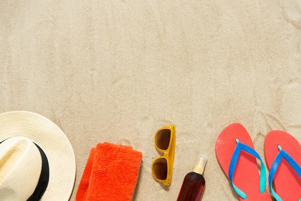 Straw hat, flip flops and sunglasses on beach sand — Stock Photo, Image