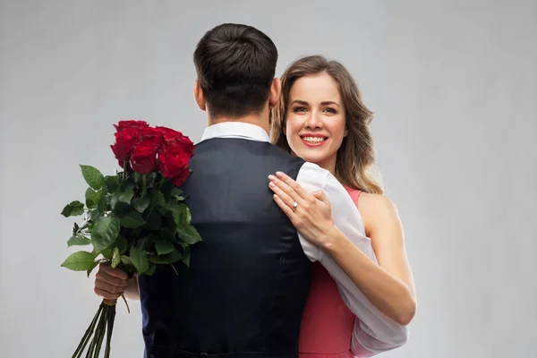 Donna con anello di fidanzamento e rose abbracciando l'uomo — Foto Stock
