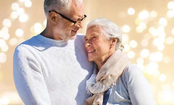 Happy senior couple over festive lights background — Stock Photo, Image