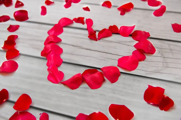 Close up of red rose petals in heart shape — Stock Photo, Image