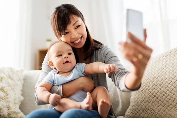 Szczęśliwa matka z synkiem w domu biorąc selfie — Zdjęcie stockowe