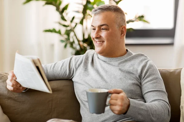 Uomo che legge giornali e beve caffè a casa — Foto Stock