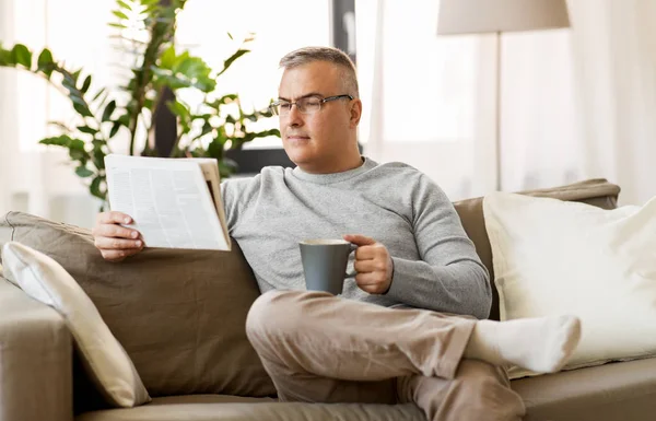 Homem lendo jornal e beber café em casa — Fotografia de Stock