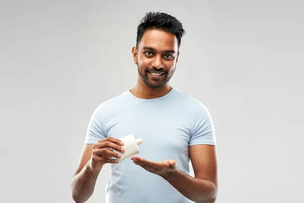 Homem indiano feliz aplicando loção em sua mão — Fotografia de Stock