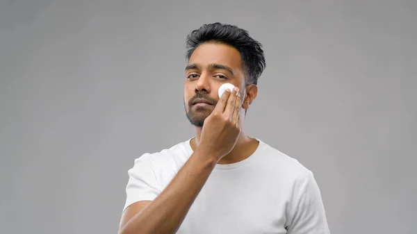 Sorridente uomo indiano pulizia viso con batuffolo di cotone — Foto Stock