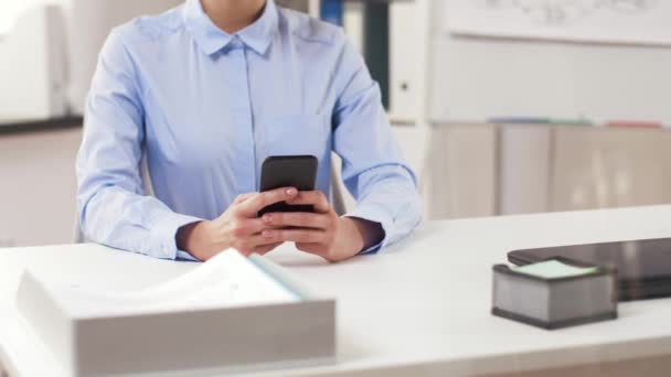 Businesswoman ze smartfonem pracującym w biurze — Wideo stockowe