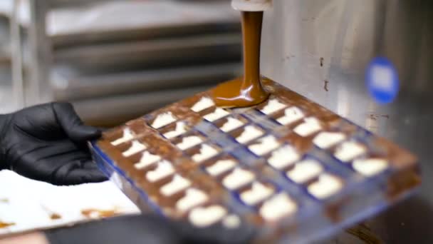 Confitero hace dulces de chocolate en la tienda de dulces — Vídeo de stock
