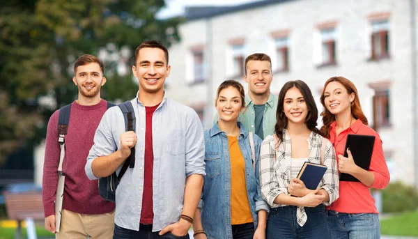 Groep lachende studenten met boeken over de campus — Stockfoto