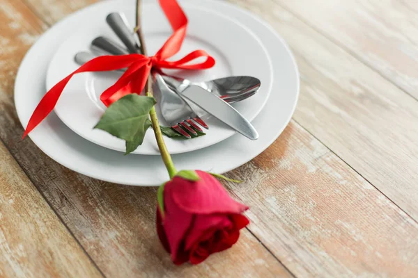 Primo piano di fiore di rosa rosso su serie di piatti — Foto Stock