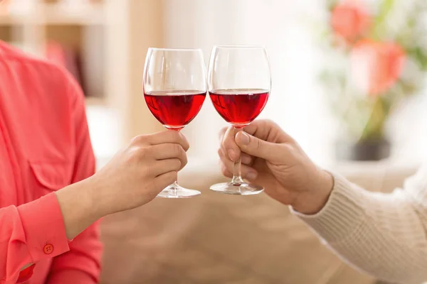 Hands of couple with red wine glasses toasting — Stock Photo, Image