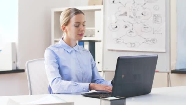 Donna d'affari con computer portatile e smartwatch in ufficio — Video Stock