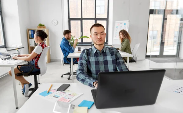 Kreativer Mann mit Laptop im Büro — Stockfoto