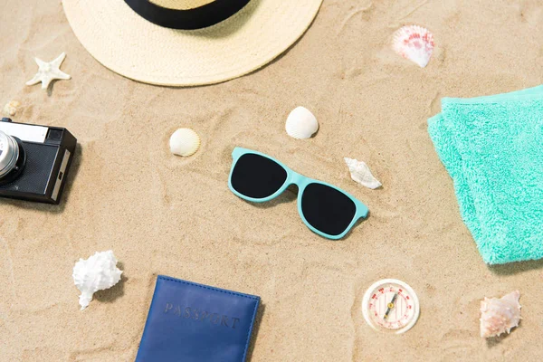 Camera, passport, sunglasses and hat on beach sand — Stock Photo, Image