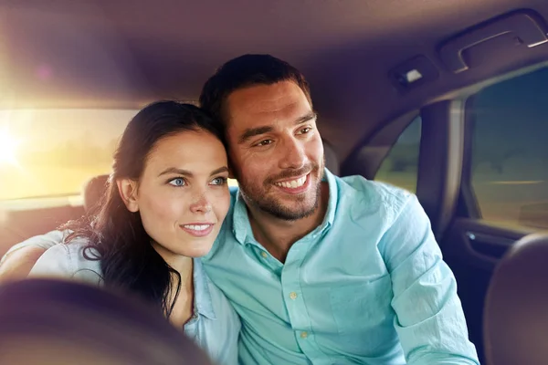 Happy man and woman riding in a taxi back seat — Stock Photo, Image