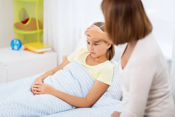 Mother taking care of unhealthy daughter at home — Stock Photo, Image