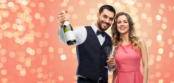 Feliz pareja con botella de champán y copas — Foto de Stock