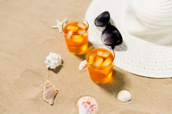 Drinkar, sol hatt och solglasögon på stranden sand — Stockfoto