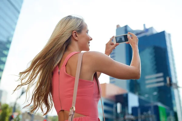 Young woman with smartphone photographing city — Stock Photo, Image