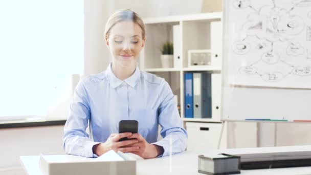 Zakenvrouw met smartphone werkt op kantoor — Stockvideo