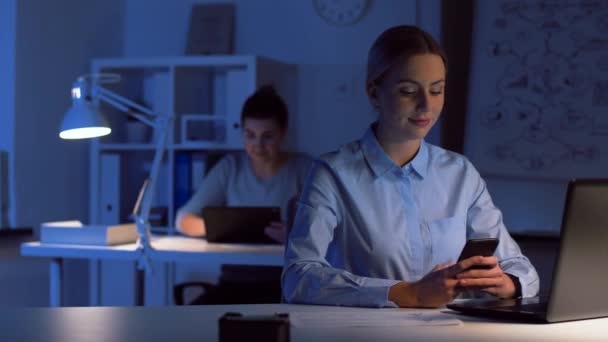 Zakenvrouw met smartphone bij donkere nacht kantoor — Stockvideo