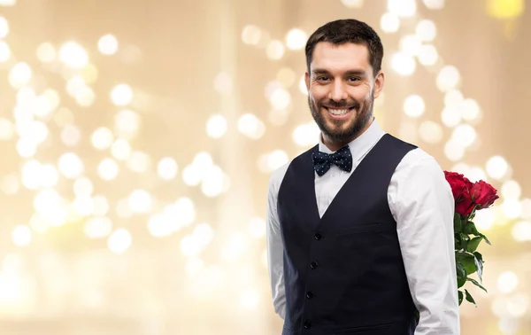 Hombre feliz con rosas rojas a sus espaldas —  Fotos de Stock