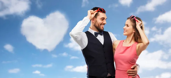 Happy couple in heart-shaped sunglasses — Stock Photo, Image