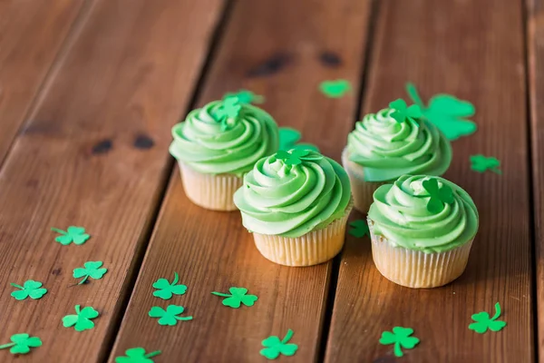 나무 식탁 위의 초록빛 컵 케익과 샴록 — 스톡 사진