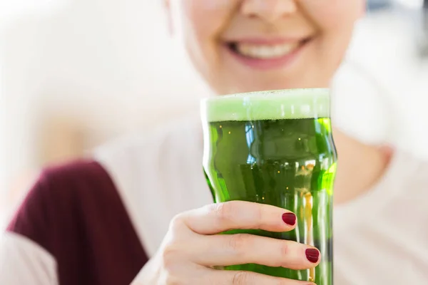 Close up of woman with green beer in glass — Stock Photo, Image